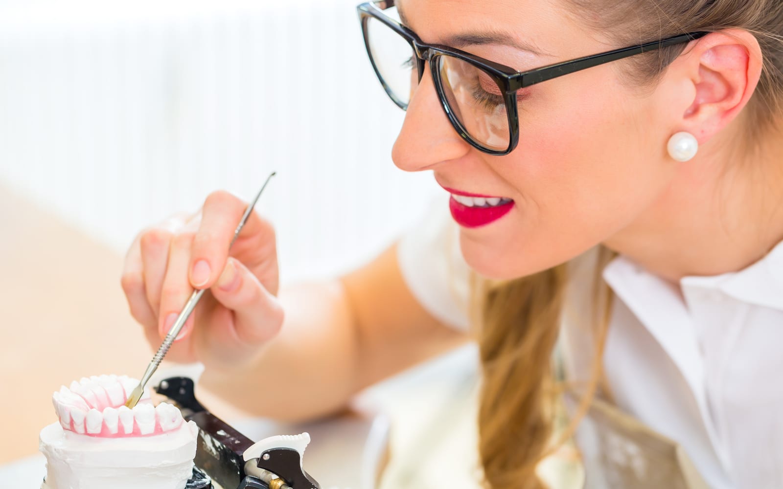 a dentist working on dentures with dental cement