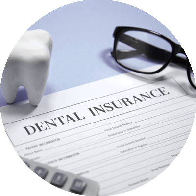 dental insurance form with glasses calculator and tooth model on desk