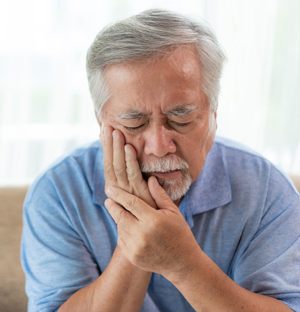 older man suffering from tooth pain